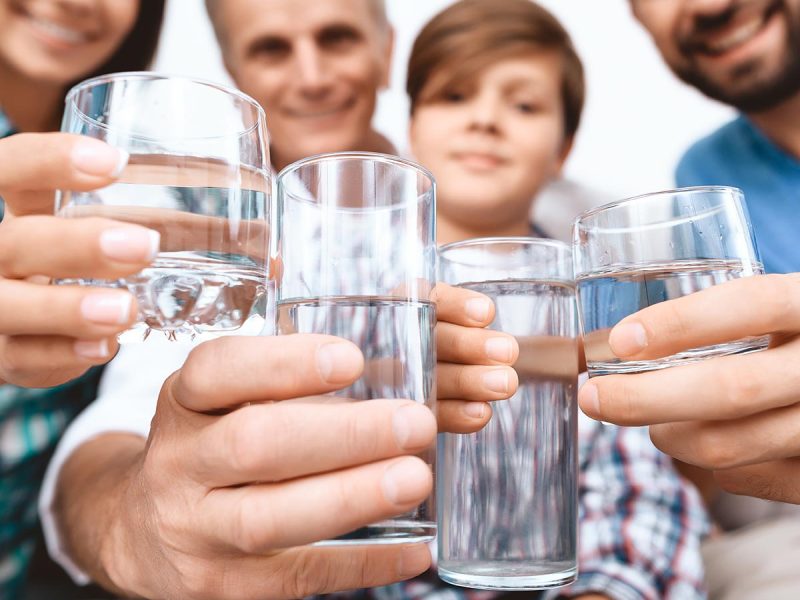 Close up. Cheerful Family cheering with glasses of water.